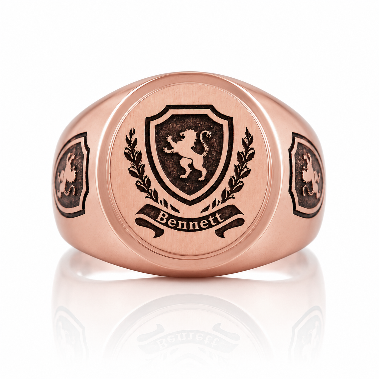 a rose gold ring with a shield-shaped emblem and the name 'Bennett' engraved on it.