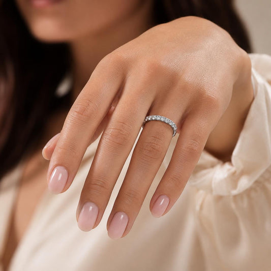 A close-up of a person's hand wearing a diamond ring on the ring finger.