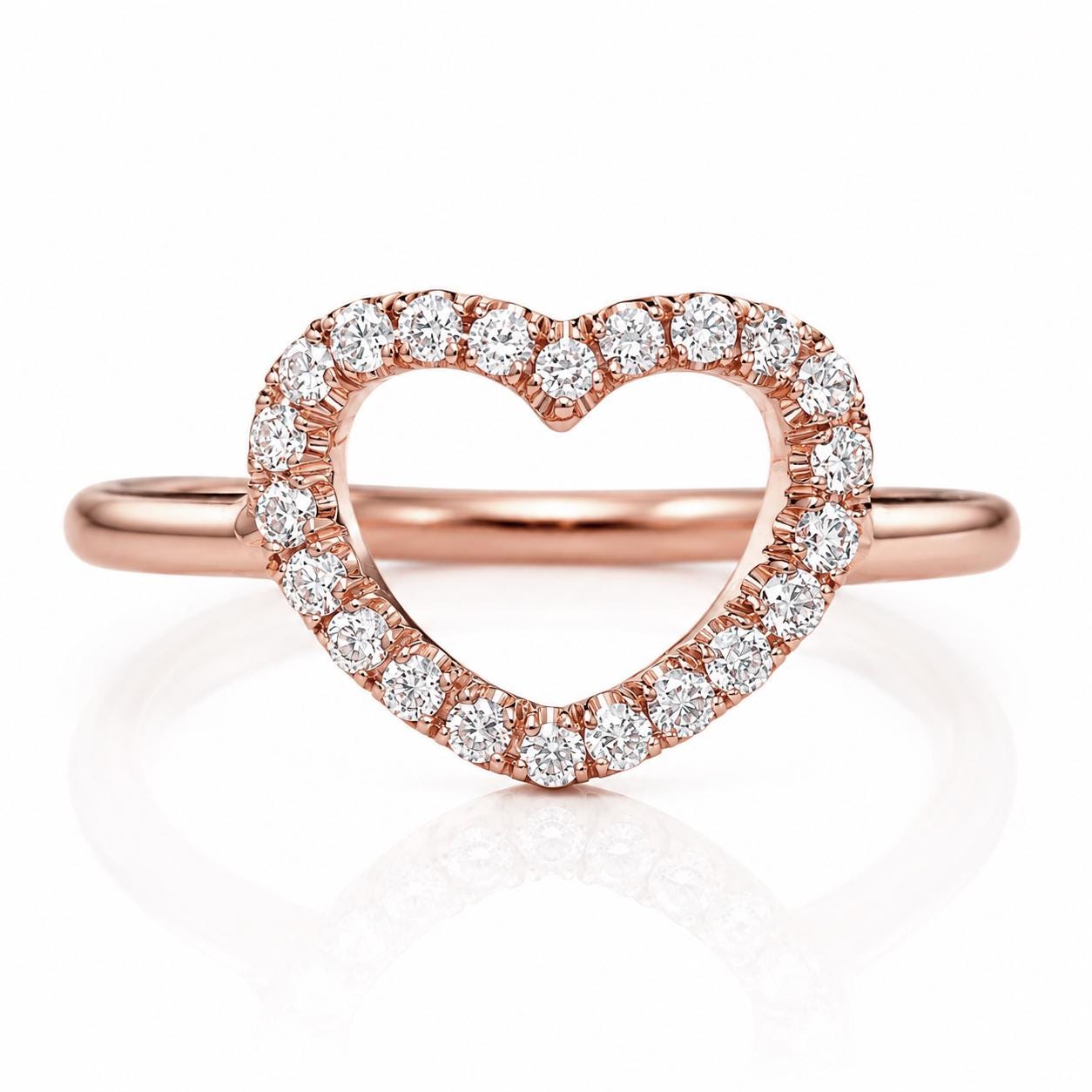 A rose gold ring with a heart-shaped cutout in the center, adorned with numerous small diamonds.