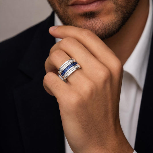A close-up of a man's hand wearing a ring with a large blue gemstone.