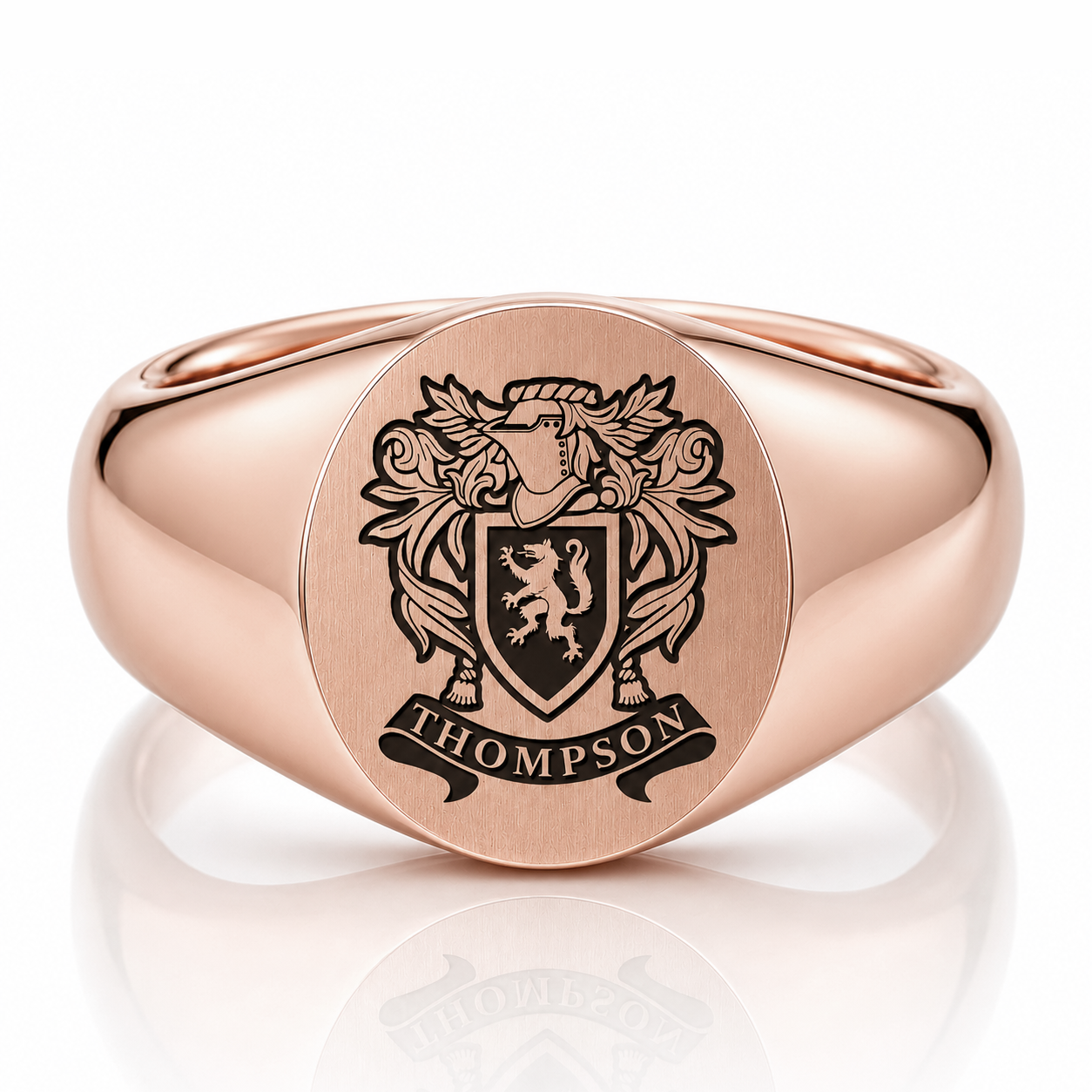 A rose gold signet ring with a coat of arms engraved on it.