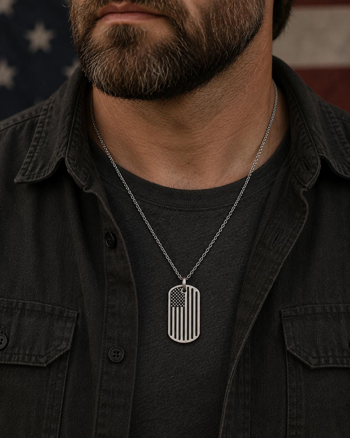 A man wearing a black jacket and a silver necklace with an American flag pendant.