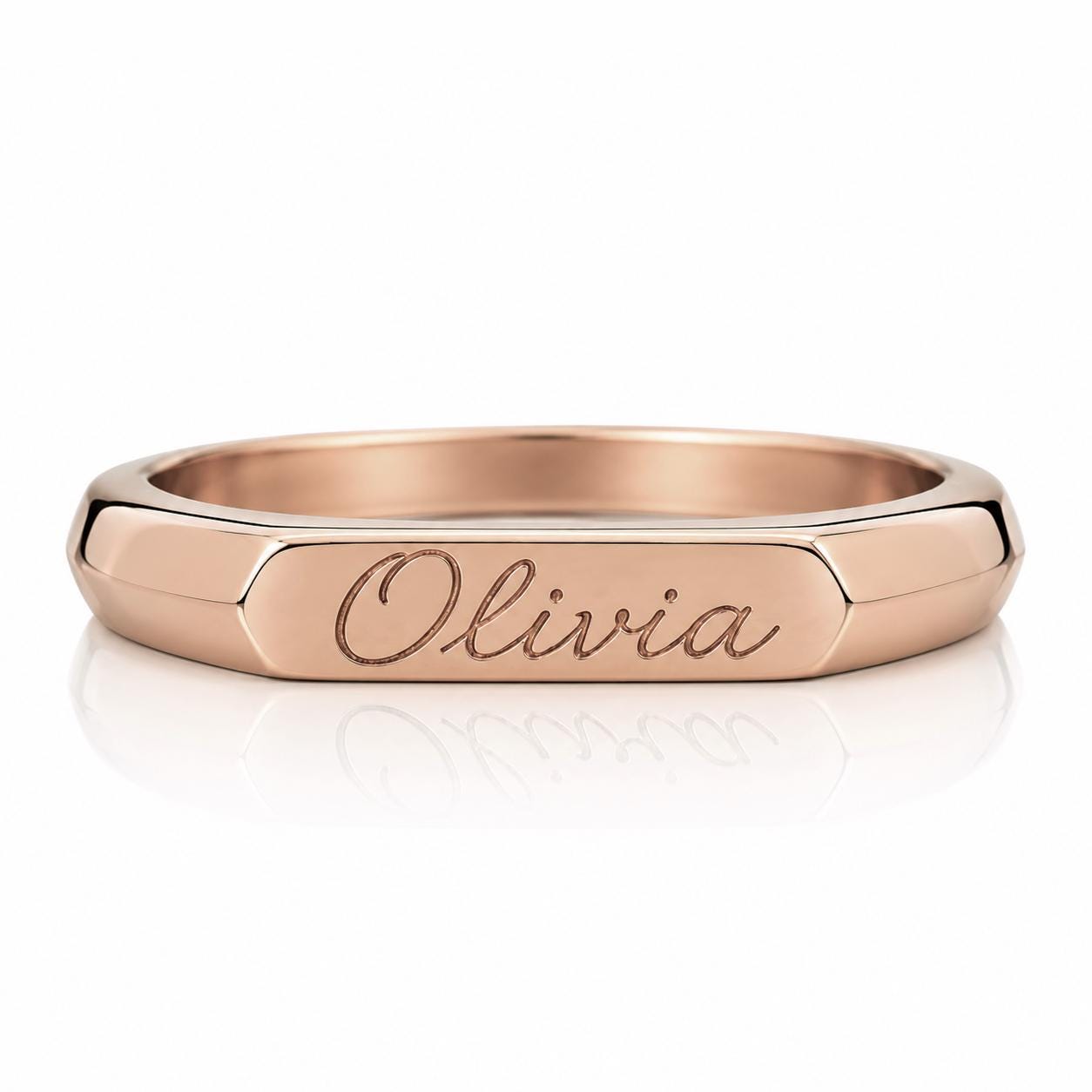 A rose gold-colored ring with the name "Olivia" engraved on it.