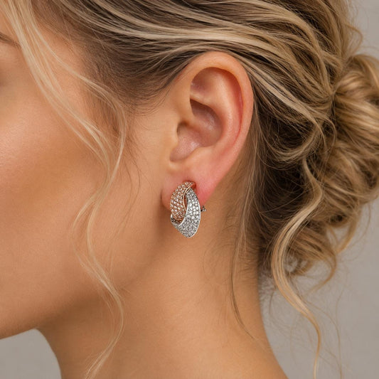 A close-up of a woman's ear wearing a pair of diamond earrings.