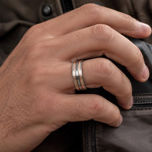 A close-up view of a person's hand wearing a ring on the ring finger.
