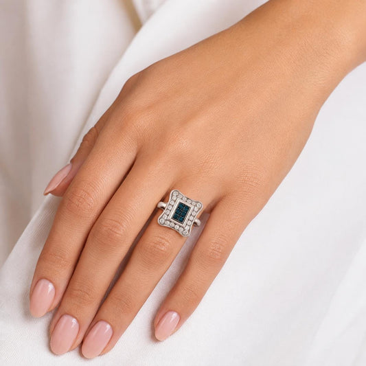 A close-up of a hand wearing a ring with a blue gemstone.
