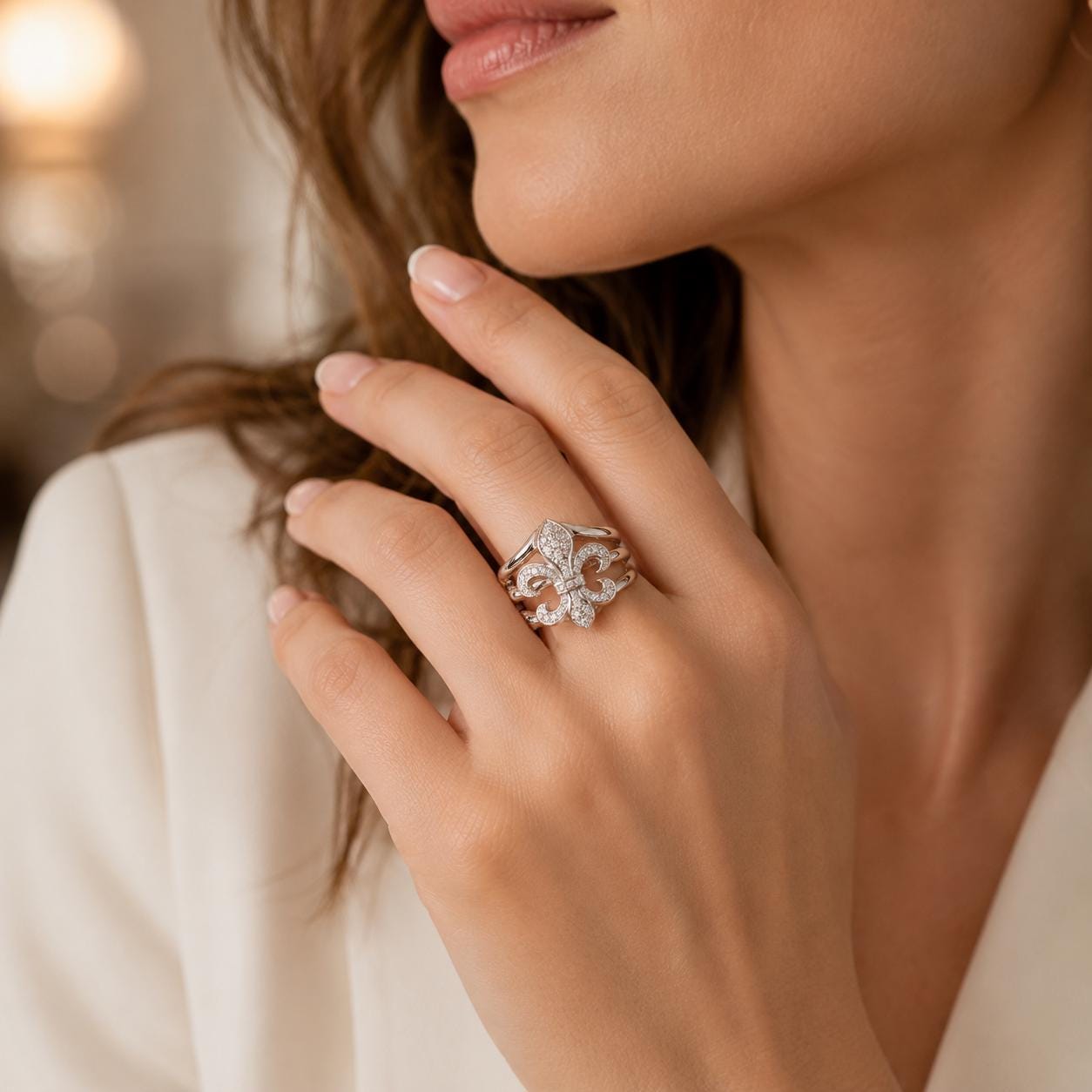A close-up of a woman's hand wearing a diamond ring, with her hair visible in the background.