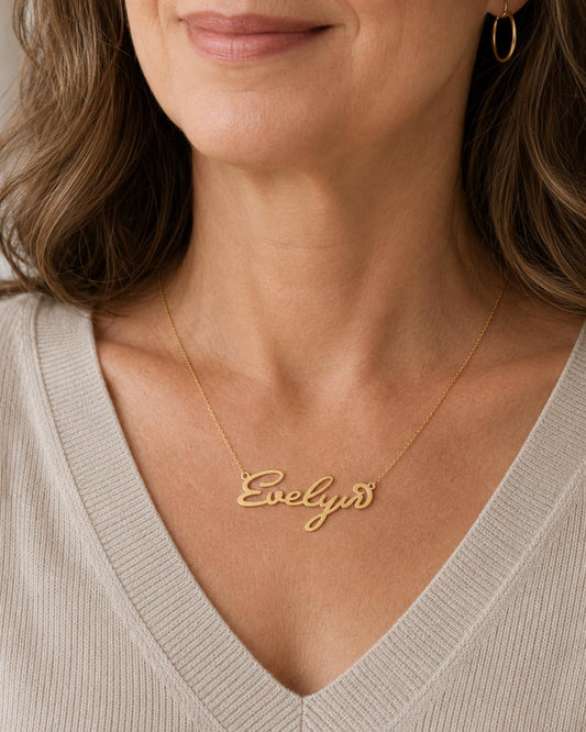 A woman wearing a necklace with the name "Ella" engraved on it.