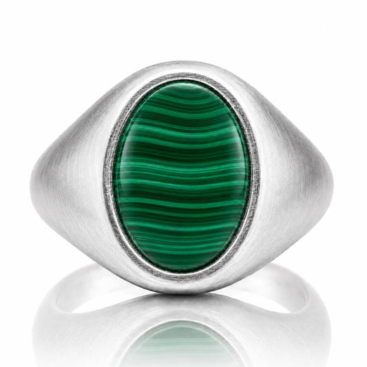 A silver ring with a large oval-shaped green gemstone in the center.
