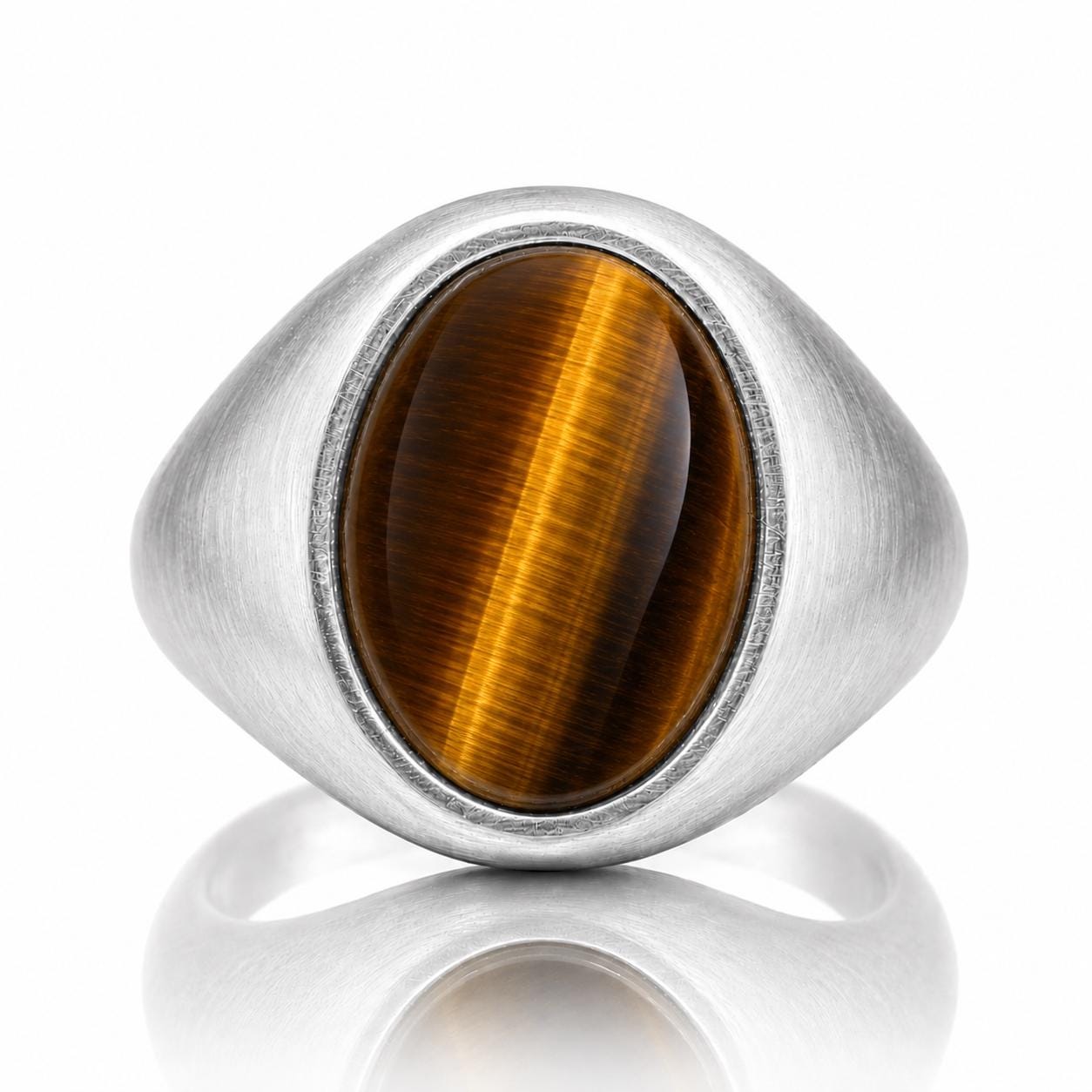 A silver ring with a large oval-shaped gemstone, likely a tiger's eye, set in the center of the ring.