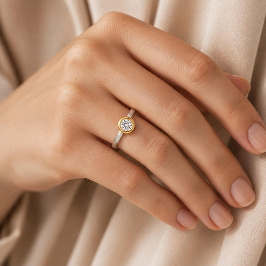 A close-up of a person's hand wearing a gold ring with a diamond in the center.