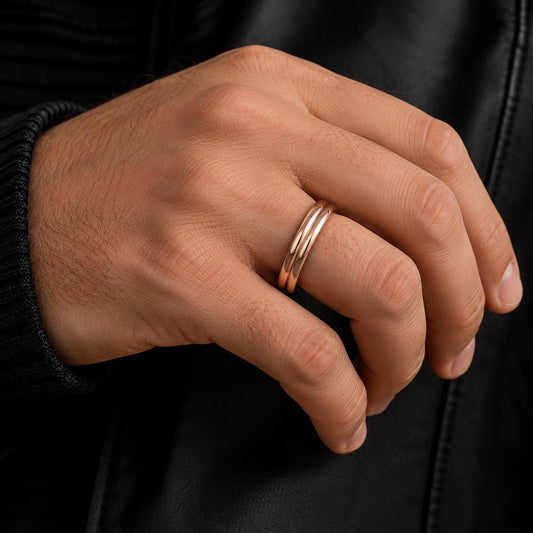 A close-up of a person's hand wearing a gold ring on the ring finger.