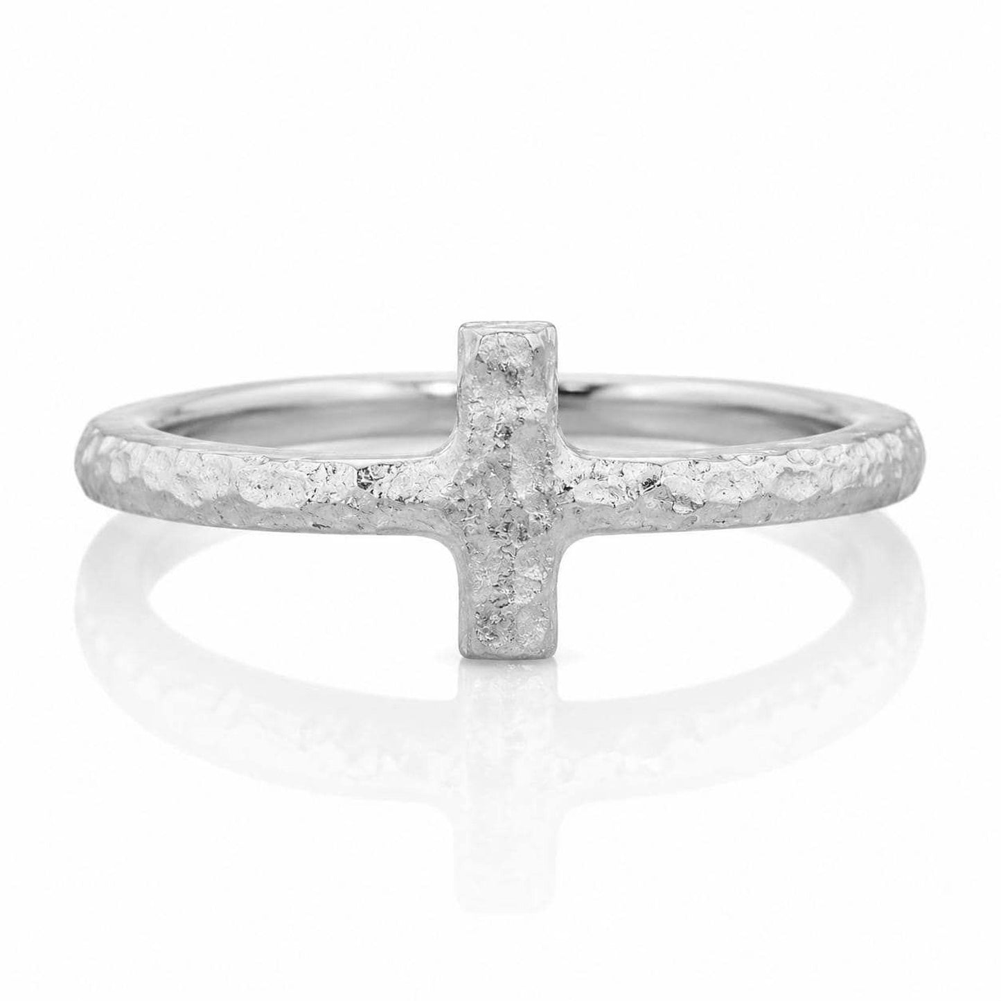 A silver ring with a large, irregularly shaped cross-shaped gemstone in the center.