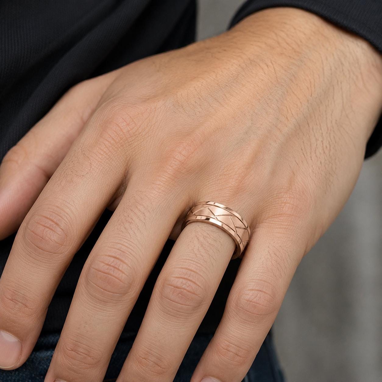 A close-up of a person's hand wearing a gold ring on the ring finger.
