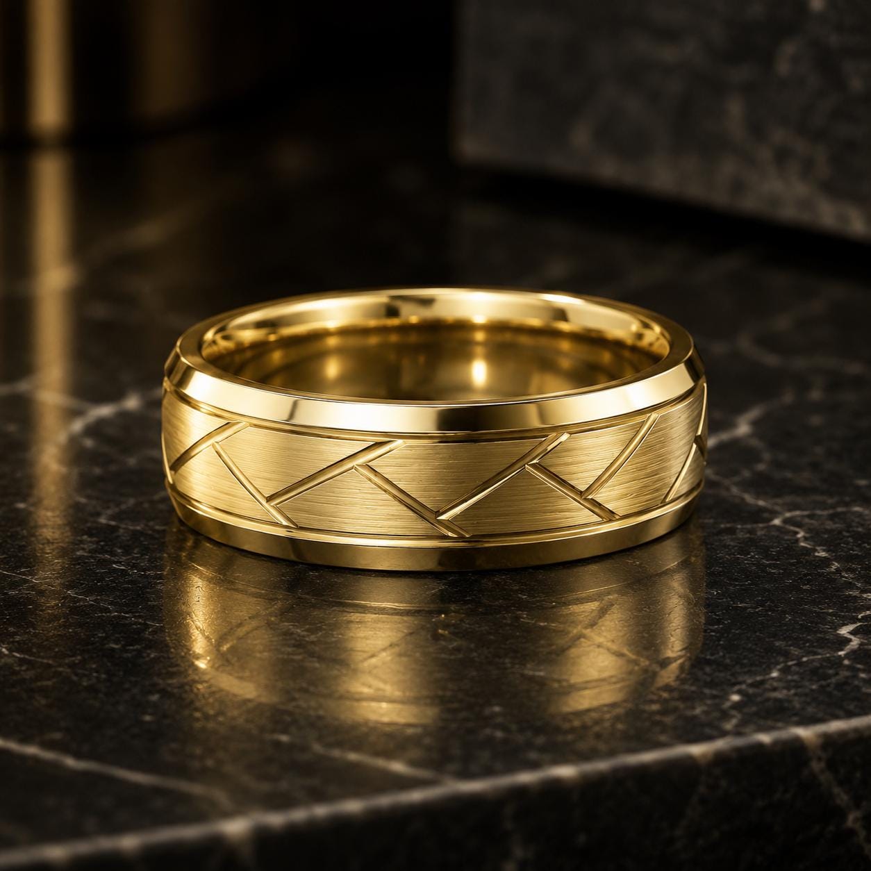 A gold ring with a diamond-like pattern sits on a black marble surface.
