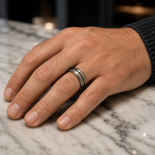A close-up image of a hand wearing a ring on a marble surface.