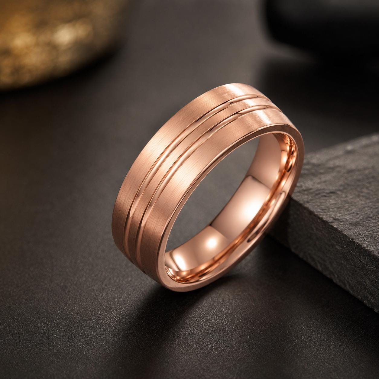 A shiny, copper-colored ring with a textured band is displayed on a dark surface.