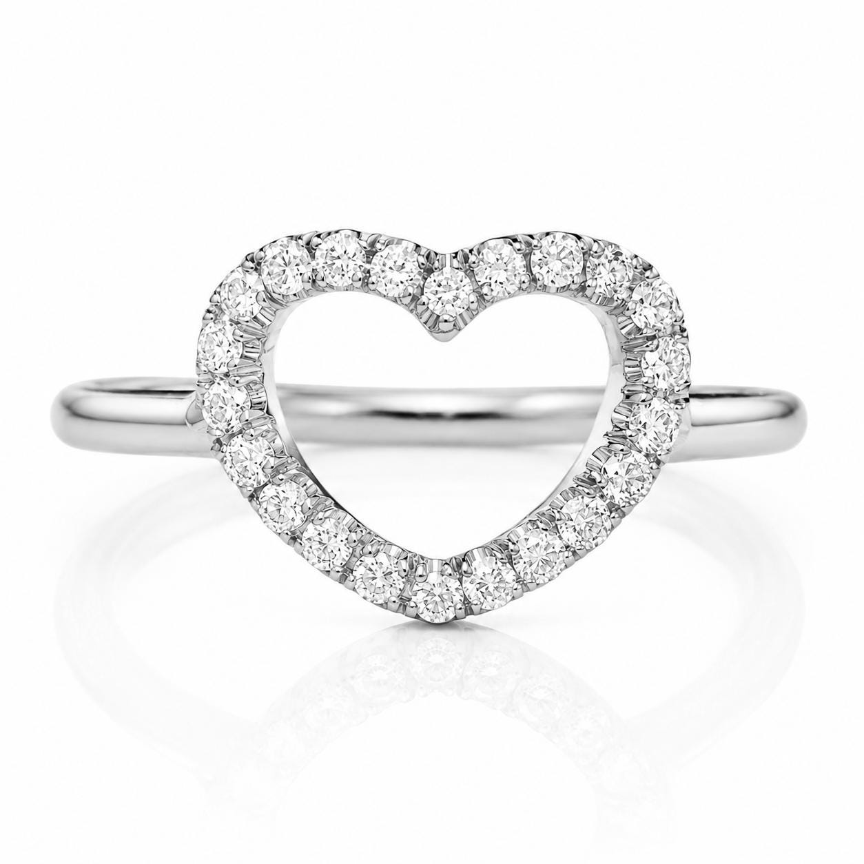 A silver ring with a heart-shaped diamond center stone surrounded by smaller diamonds.
