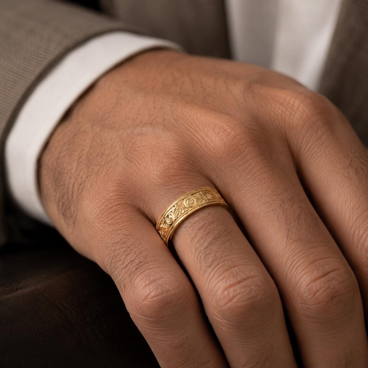 A close-up of a person's hand wearing a gold ring on the ring finger.