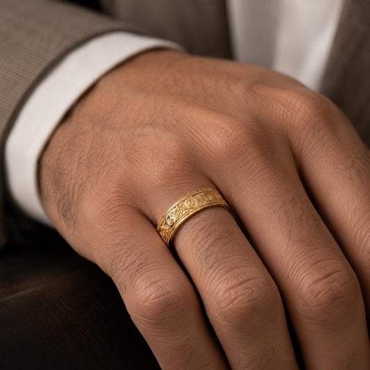 A close-up of a person's hand wearing a gold ring on the ring finger.