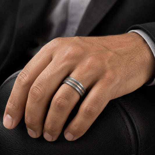 A close-up image of a person's hand wearing a ring on the ring finger.