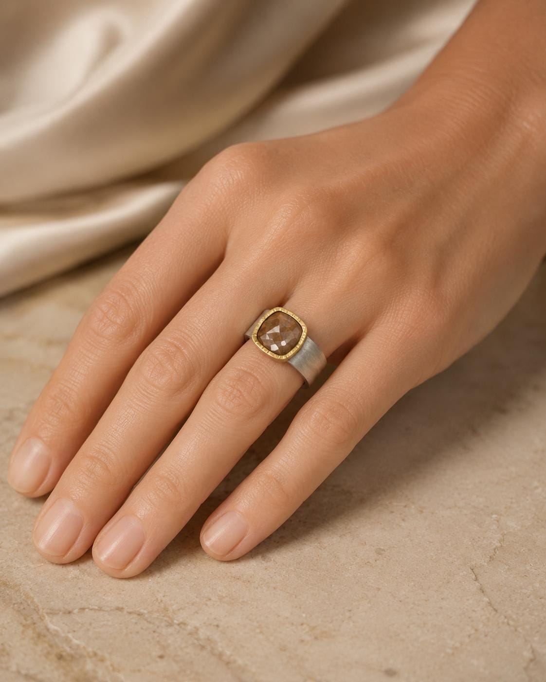 A close-up image of a hand wearing a ring with a large, oval-shaped gemstone.