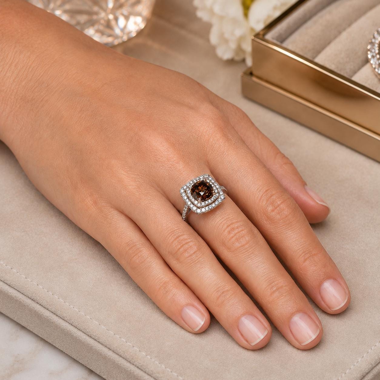 A close-up of a hand wearing a diamond ring with a large central stone surrounded by smaller stones.