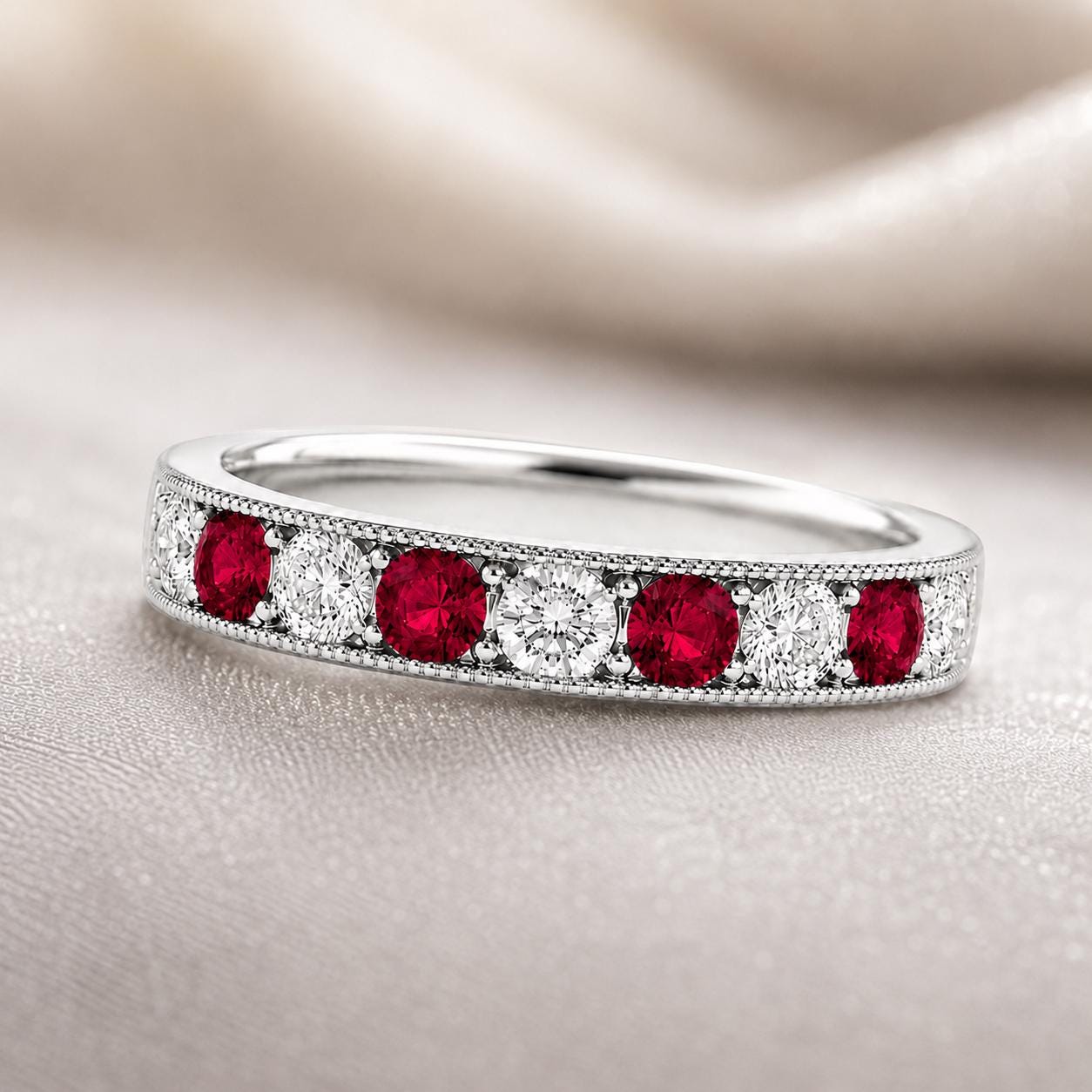 A silver ring with a row of red gemstones, including diamonds, set in a decorative pattern.