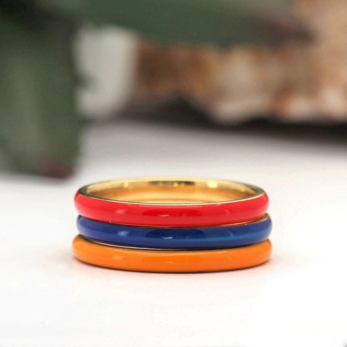 A stack of three colorful rings, with the top ring being red, the middle ring being blue, and the bottom ring being orange.