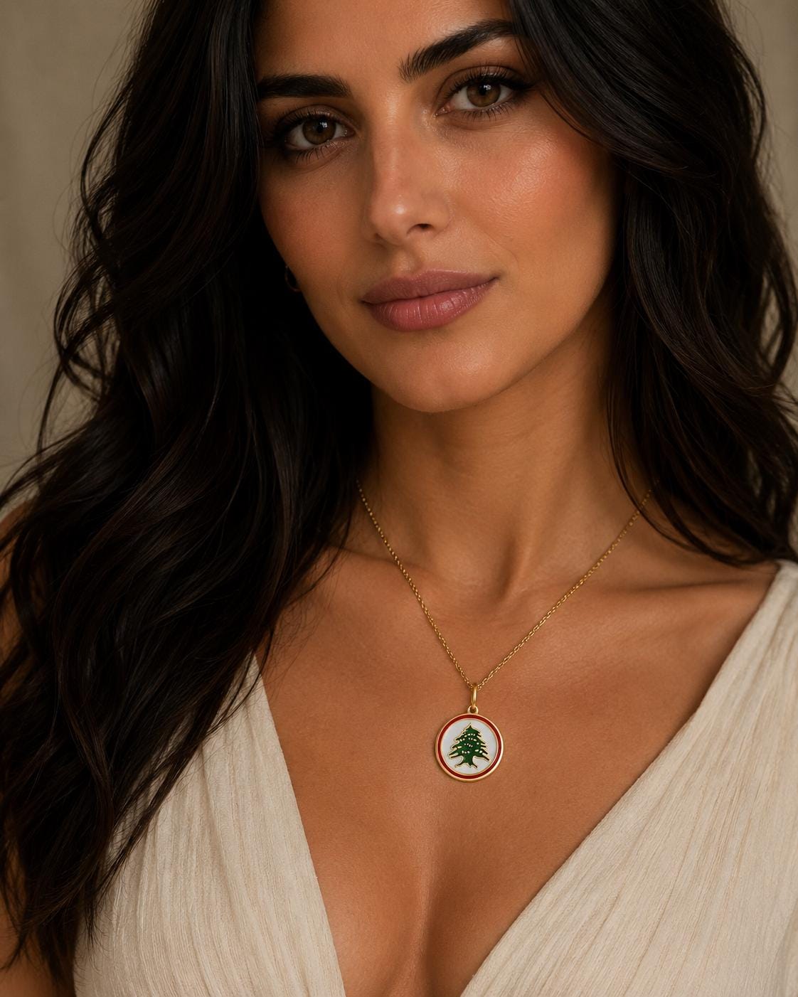 A woman with long dark hair wearing a white dress and a necklace with a pendant.