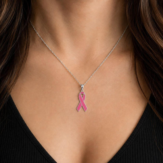 A close-up of a woman's neck and chest area, with a silver necklace featuring a pink ribbon pendant.