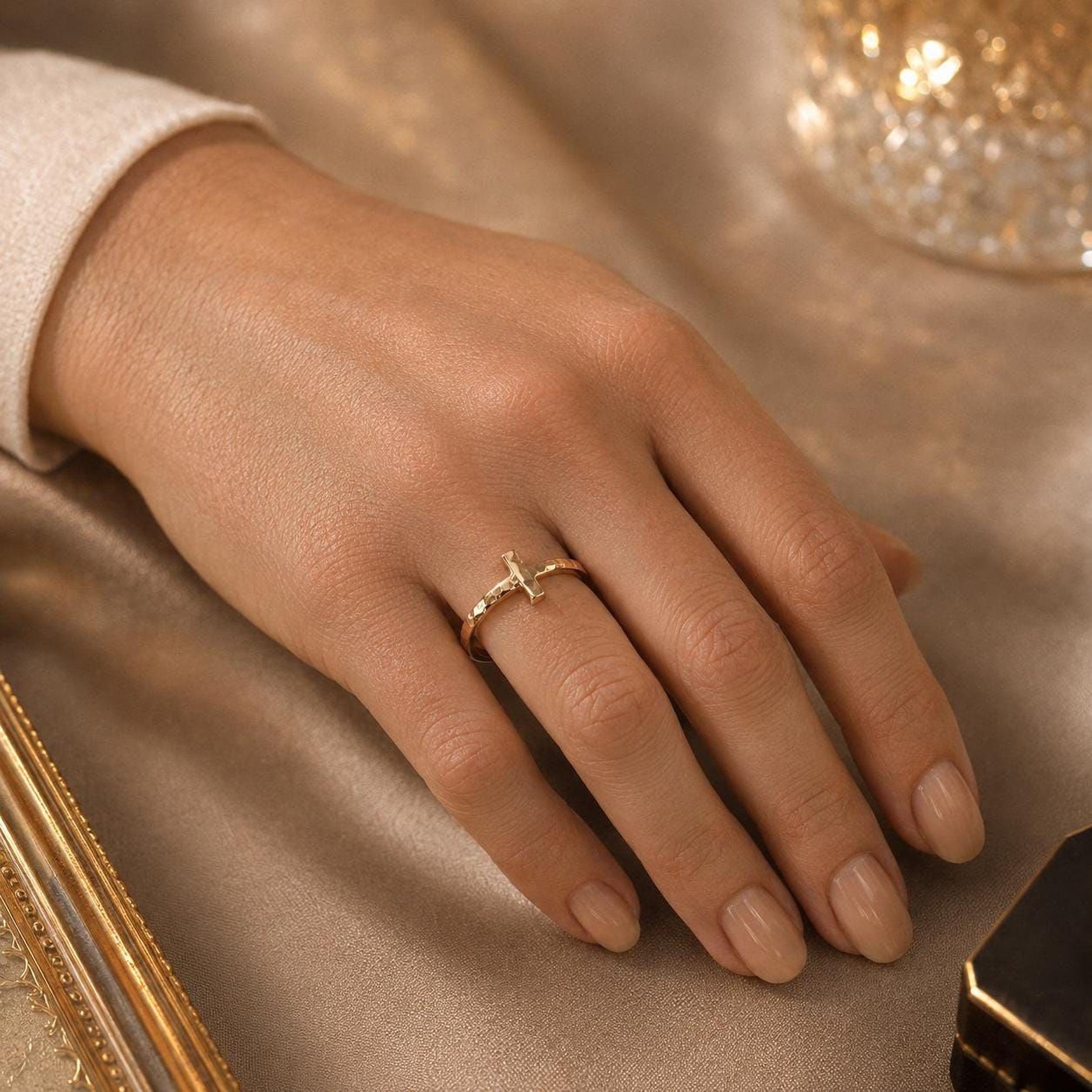 A close-up of a person's hand wearing a gold ring on the ring finger.