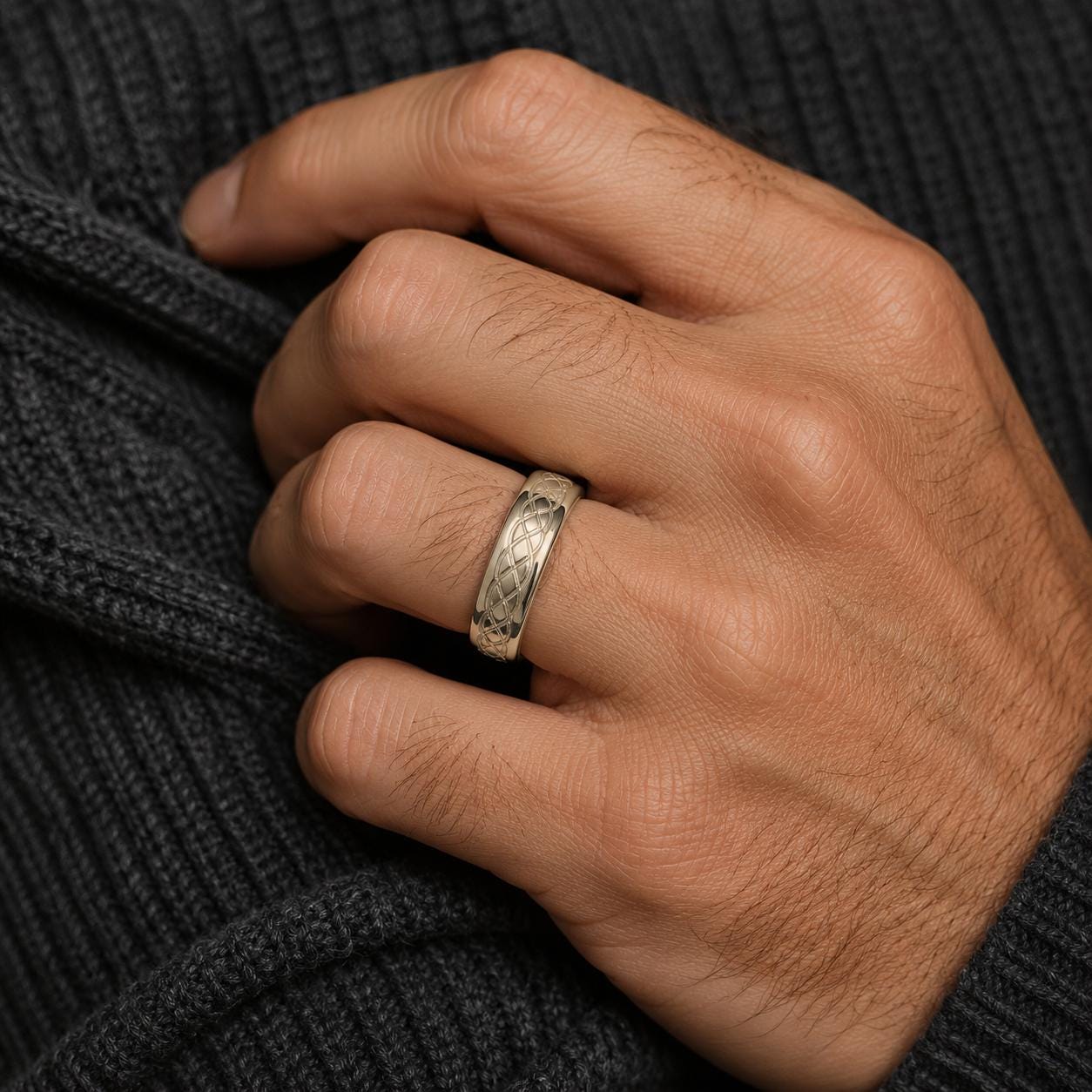 A close-up of a hand wearing a gold ring on the ring finger.