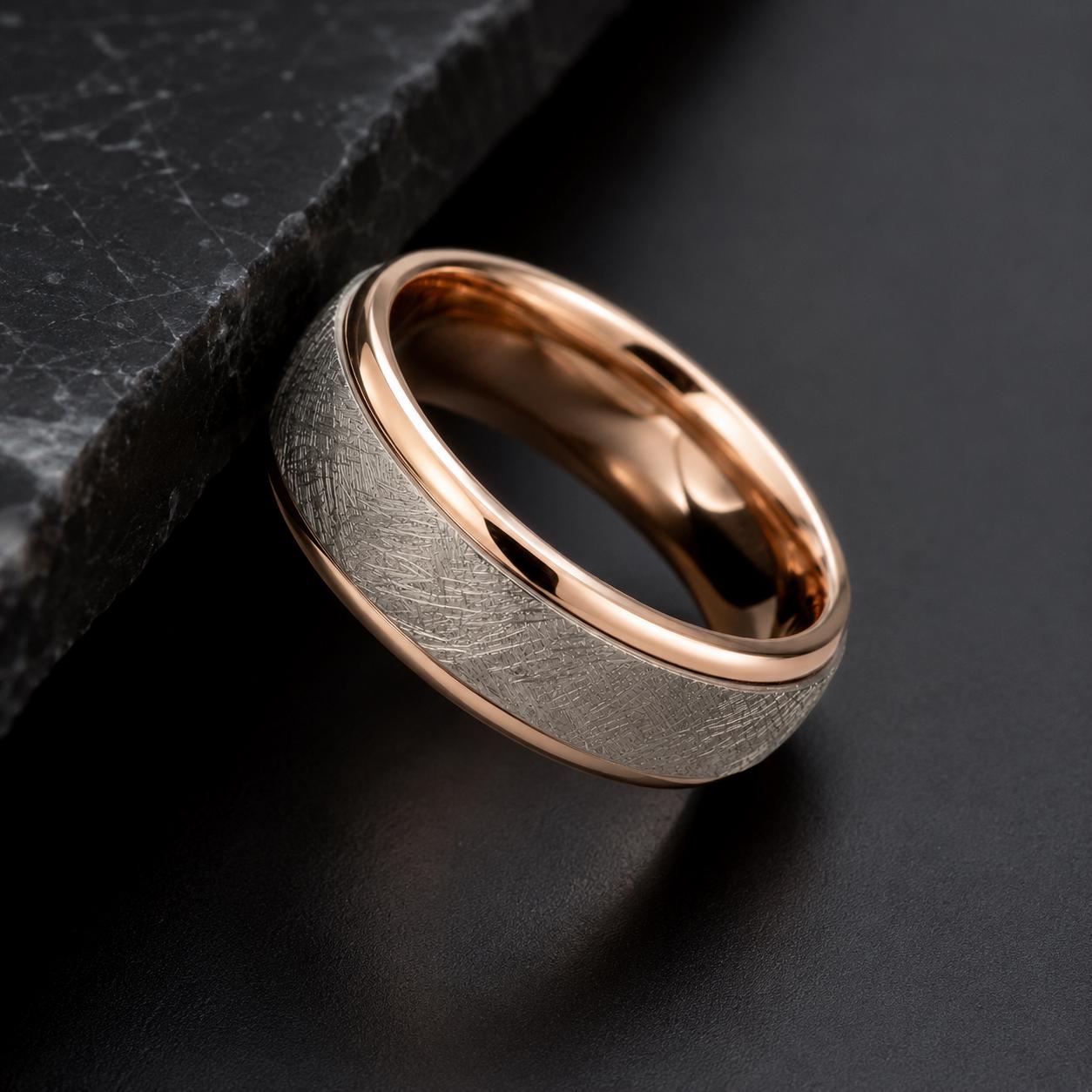 A gold-toned ring with a textured band rests on a black surface.