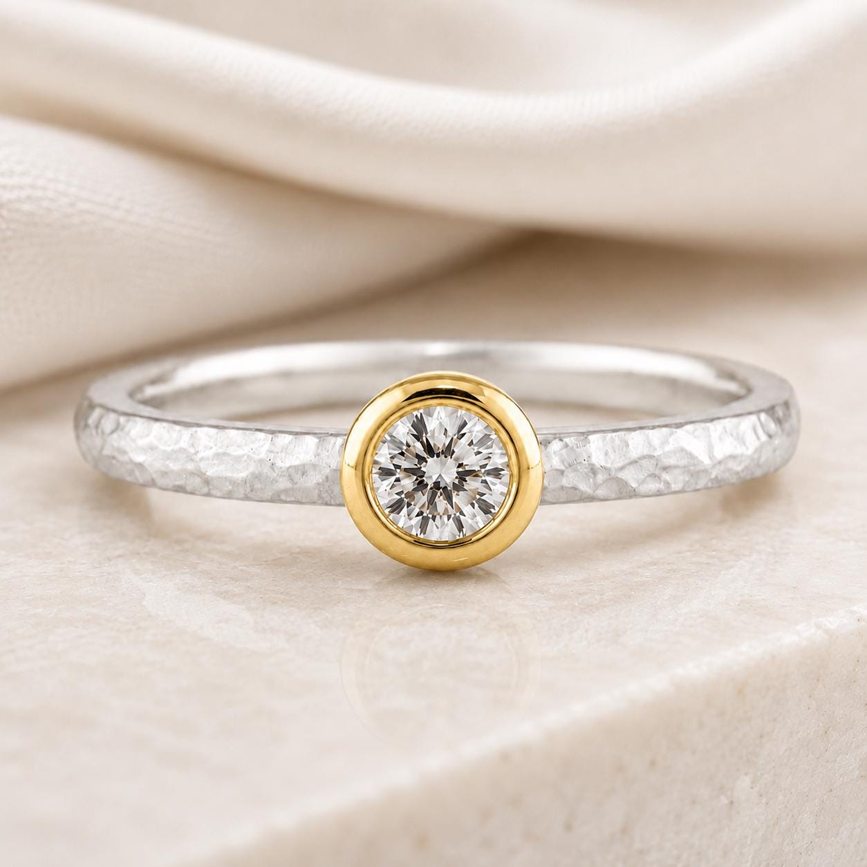 A close-up image of a diamond ring with a large central diamond surrounded by a smaller diamond in a gold-toned band.