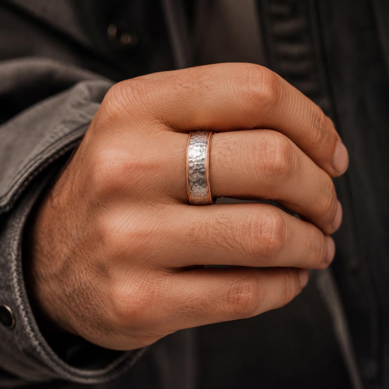 A close-up of a person's hand wearing a ring on the ring finger.