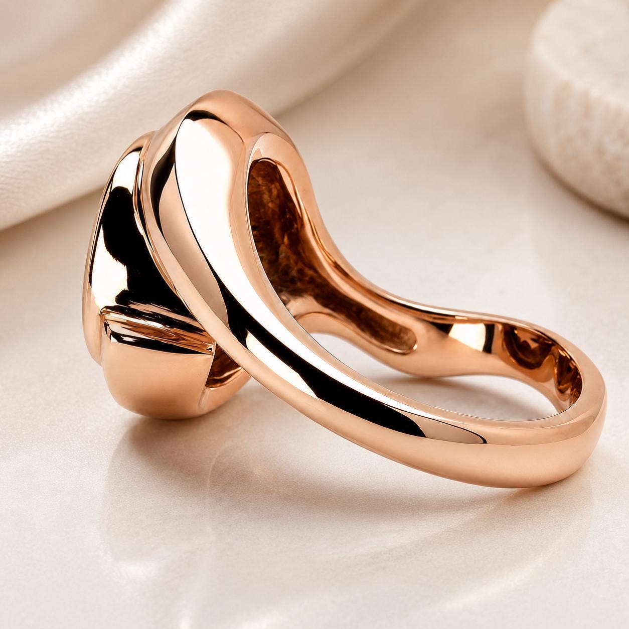 A close-up image of a shiny, gold-colored ring with a unique, curved design.