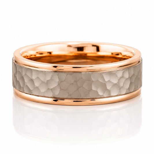 A gold and grey ring with a textured surface, set in a thin gold band.