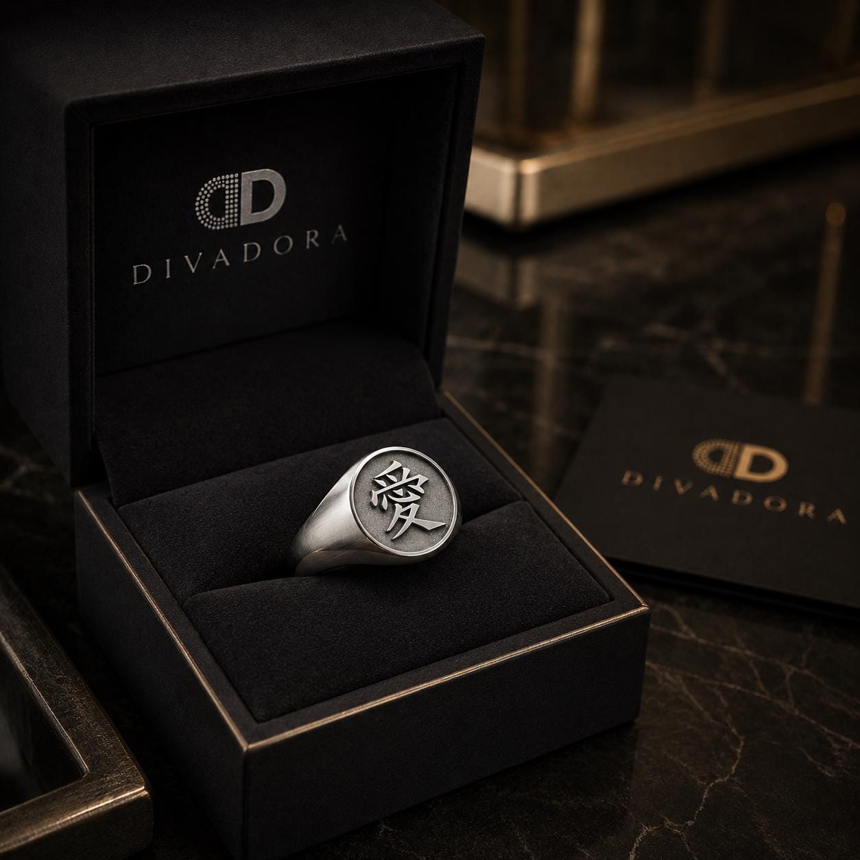 A silver ring with a symbol on it is displayed in a black jewelry box with the Divador logo, placed on a marble surface.