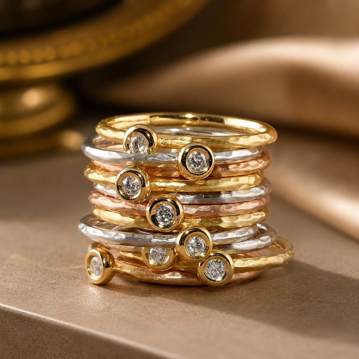 A stack of rings with various colored gemstones, including diamonds, on a surface.