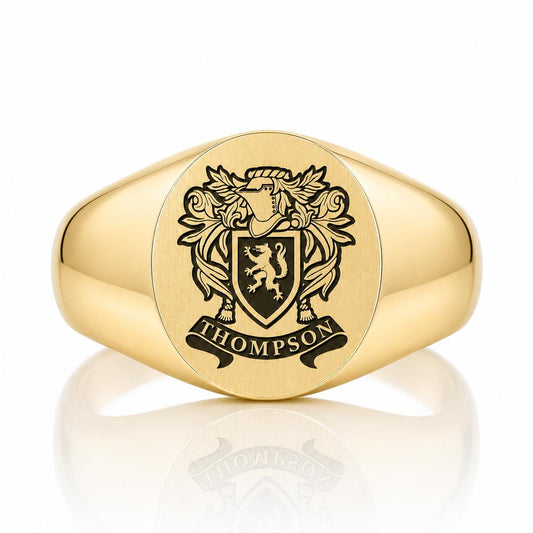 A gold ring with a crest engraved on it.