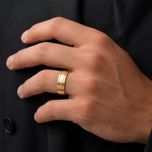 A close-up of a person's hand wearing a gold ring on the ring finger.