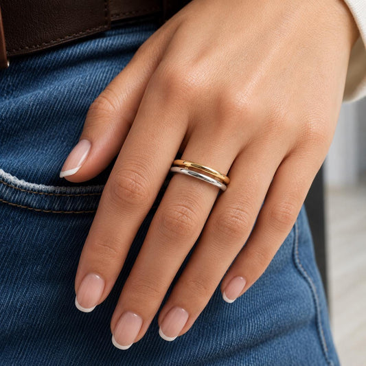 A close-up of a person's hand wearing a ring with three rings stacked on top of each other.