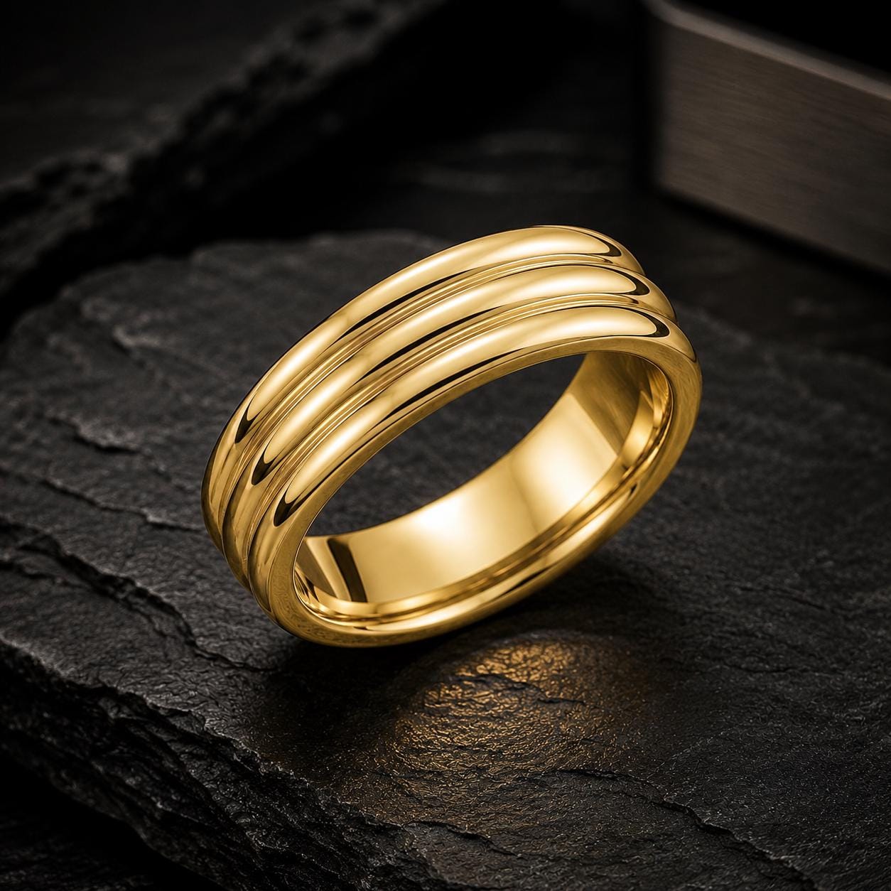 A shiny gold ring with a three-band design is displayed on a dark surface.