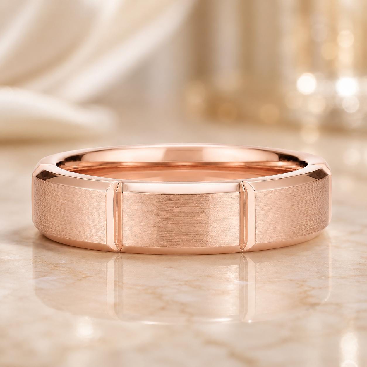 A close-up image of a rose gold ring with a textured surface, placed on a marble surface.