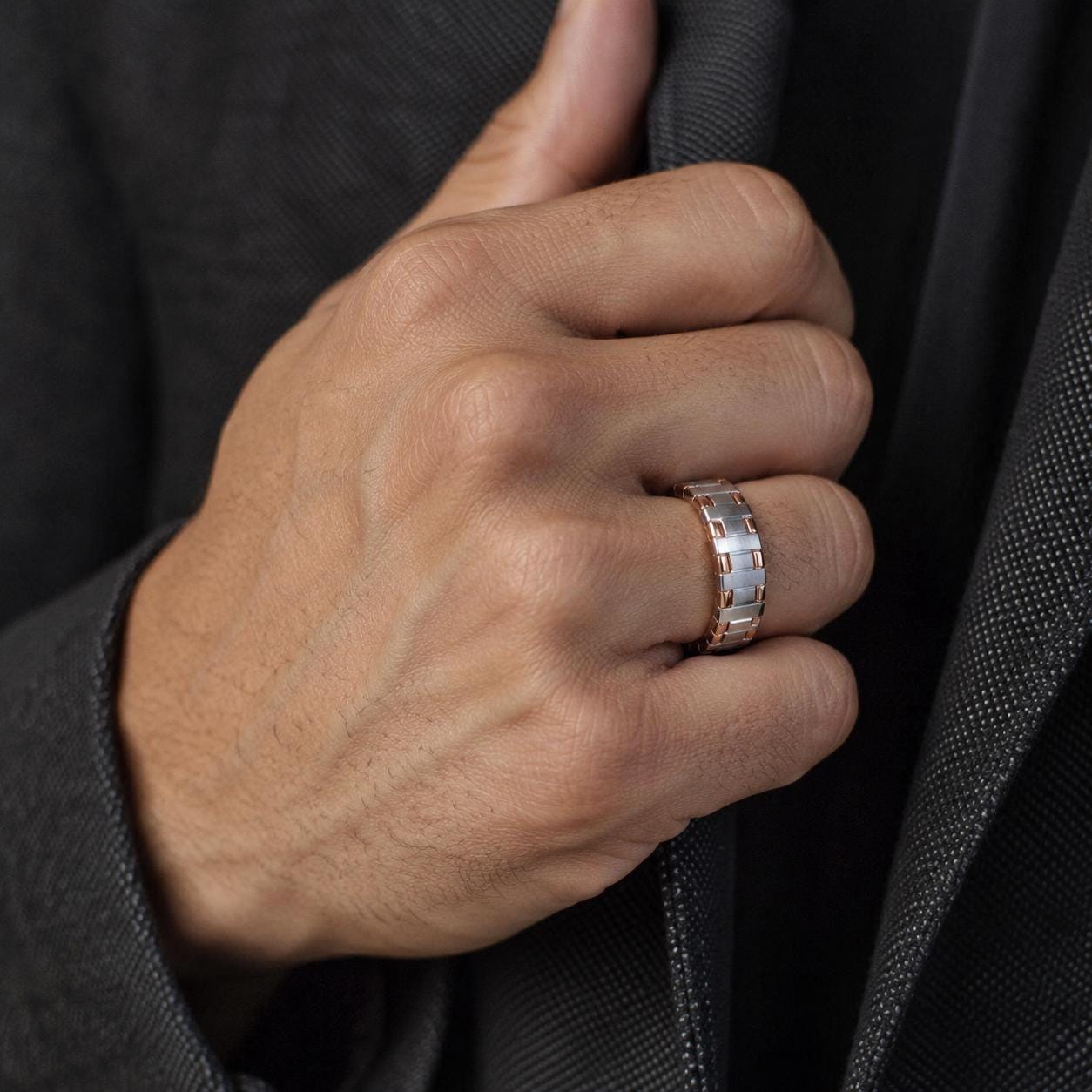 A close-up of a person's hand wearing a ring on the ring finger.