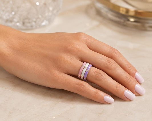 A close-up of a hand wearing a ring with three concentric bands of different colors.