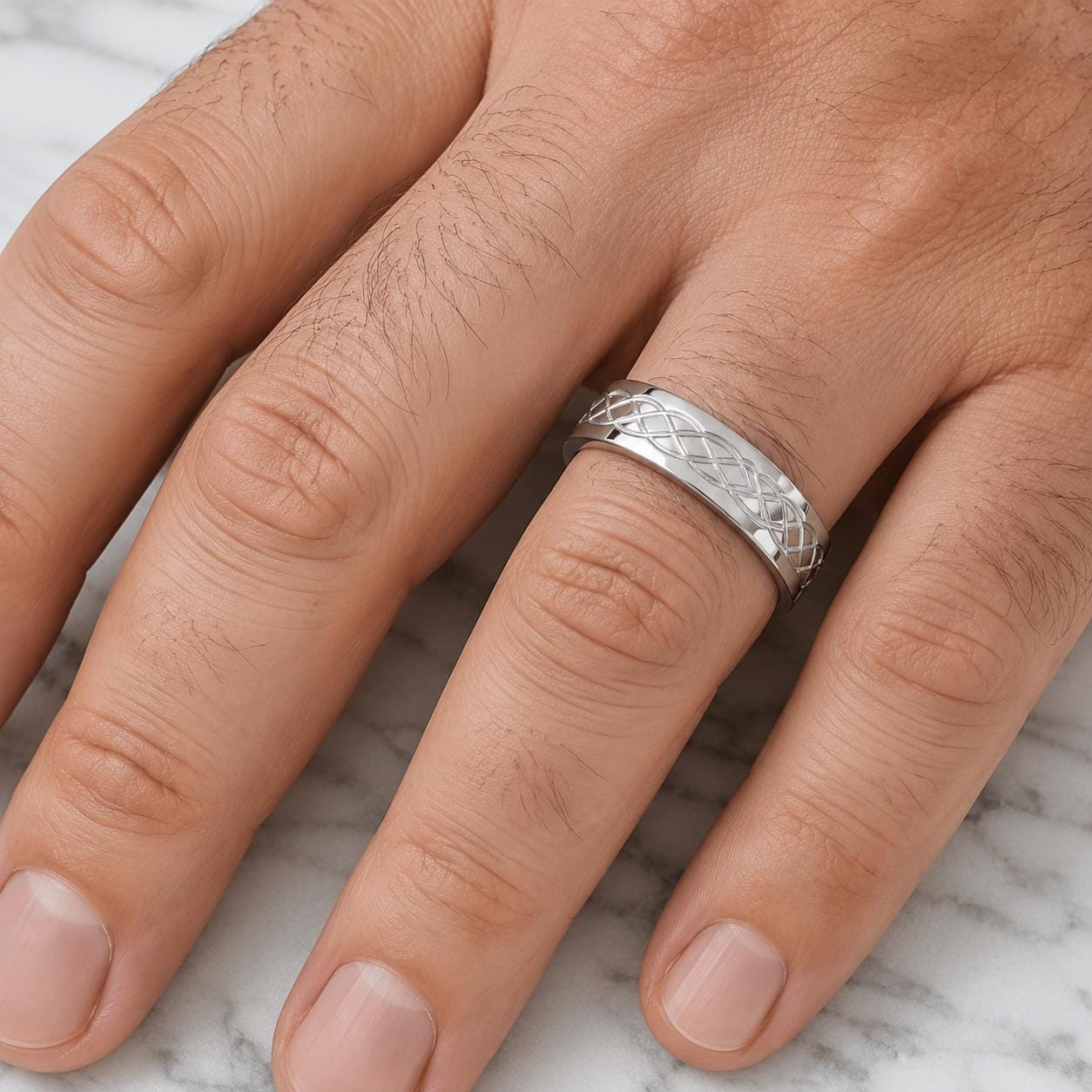 A close-up image of a person's hand wearing a silver ring on the ring finger.