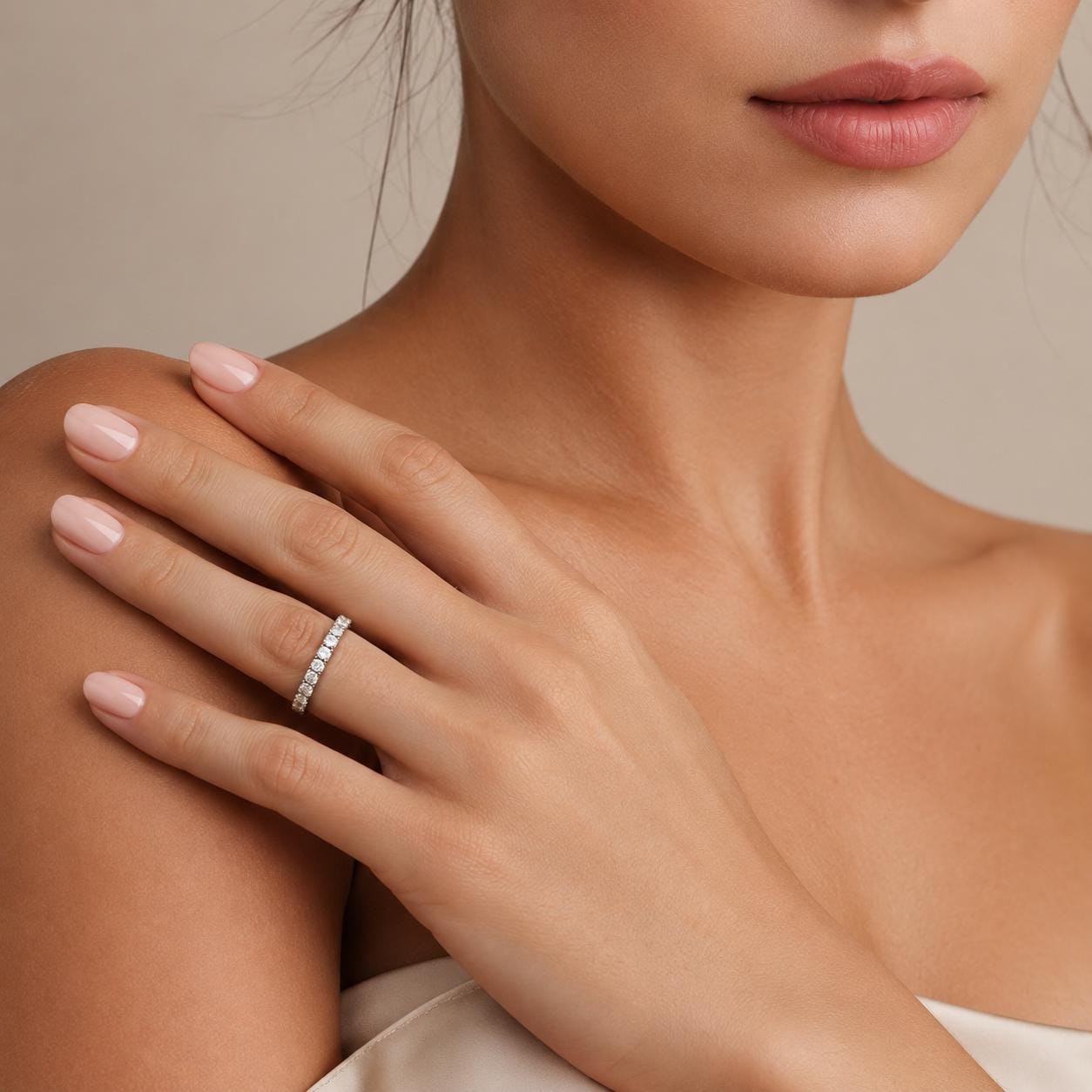 A close-up of a woman's hand wearing a diamond ring, with her chin and neck visible.