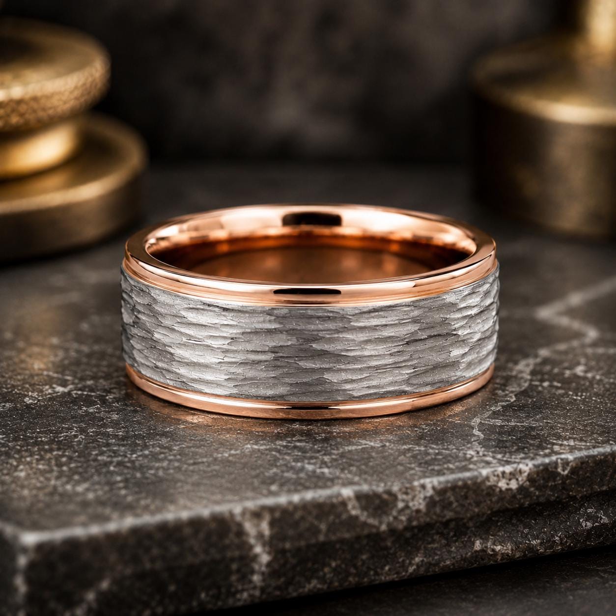 A close-up image of a silver ring with a textured band, placed on a dark surface.